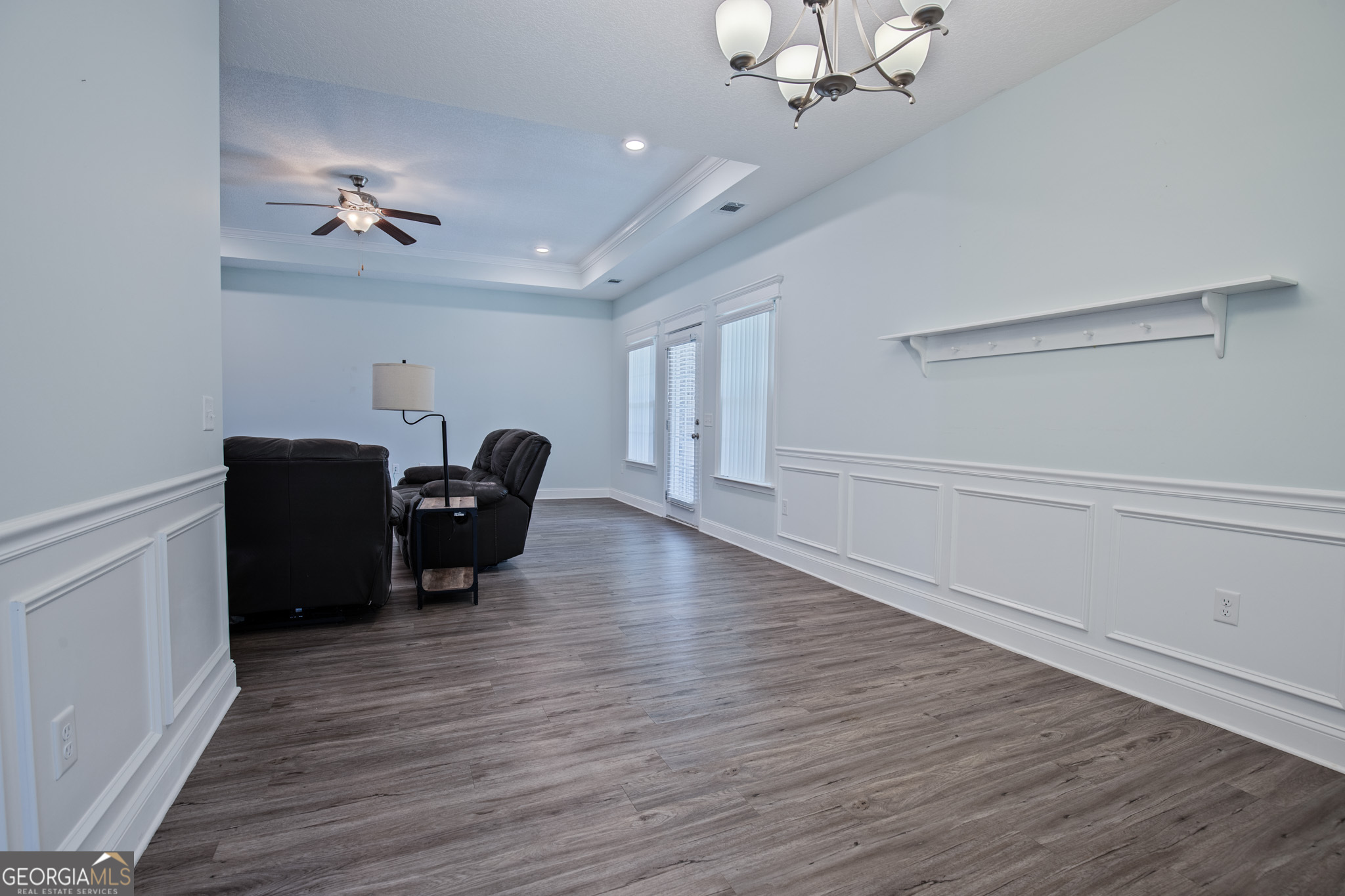3453 John Wells Road Ludowici, GA 31316 - Photo 18 of 51 an empty room with wooden floor ceiling fan and windows
