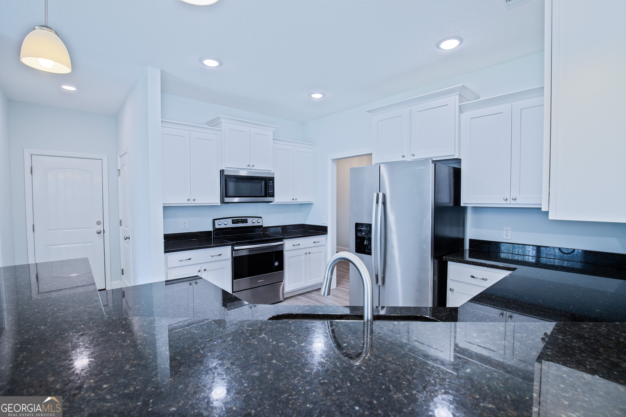 3453 John Wells Road Ludowici, GA 31316 - Photo 23 of 51 a kitchen with granite countertop a refrigerator and a stove top oven