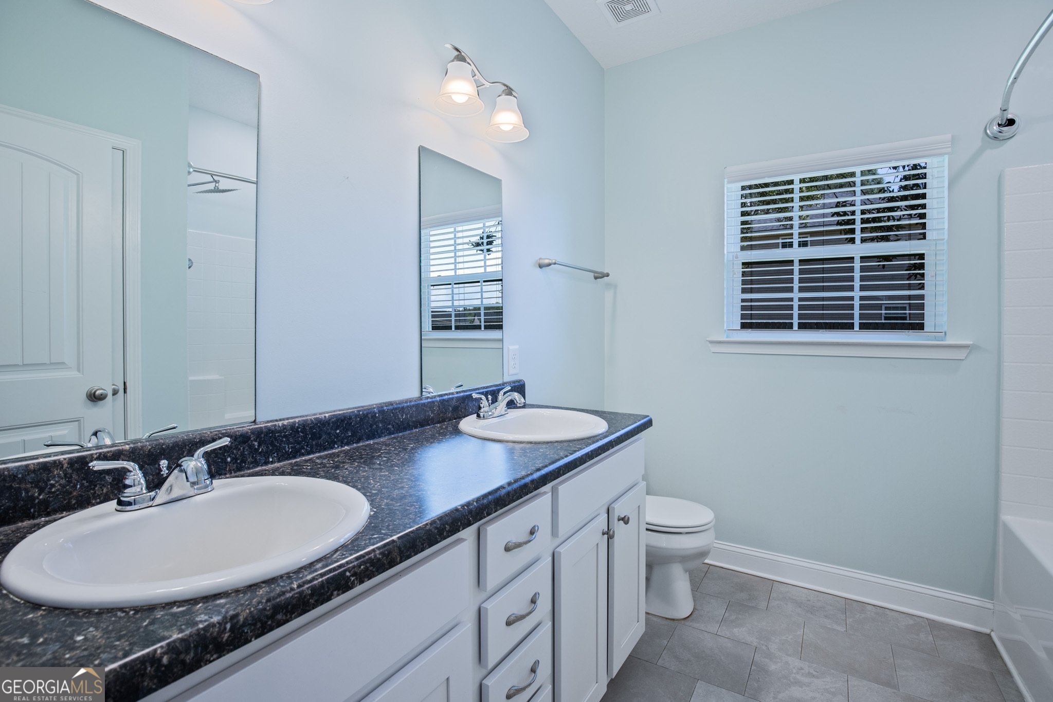 3453 John Wells Road Ludowici, GA 31316 - Photo 32 of 51 a bathroom with a granite countertop sink a toilet a mirror and a window