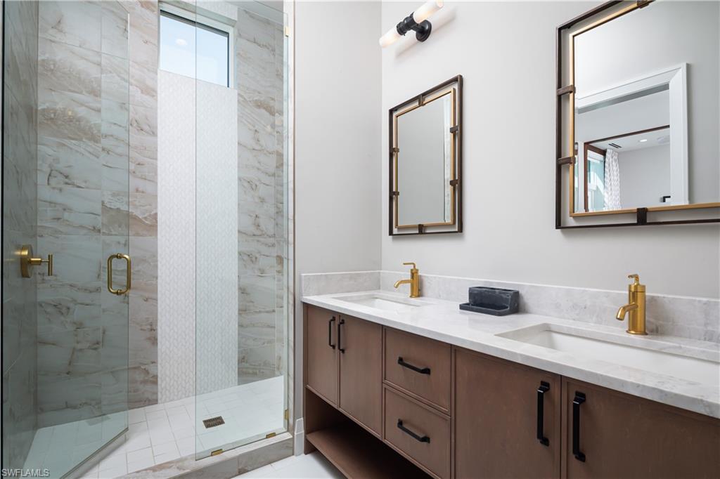 441 Mooring Line Drive Naples, FL 34102 - Photo 37 of 50 a bathroom with a double vanity sink mirror and shower