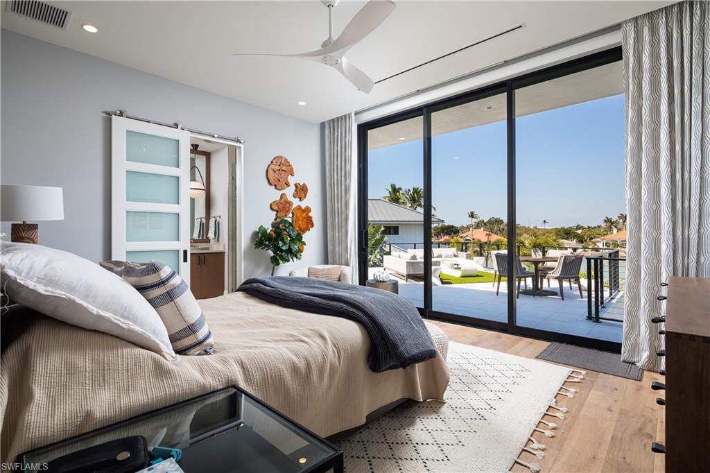 441 Mooring Line Drive Naples, FL 34102 - Photo 38 of 50 a bedroom with a large bed and a balcony view