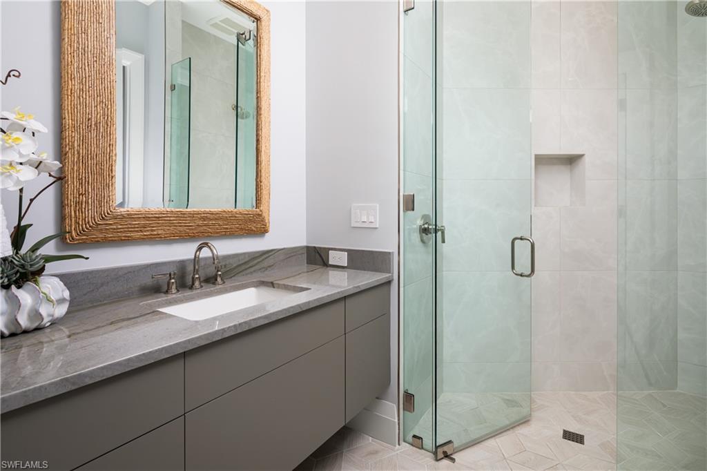 441 Mooring Line Drive Naples, FL 34102 - Photo 42 of 50 a bathroom with a granite countertop sink a mirror and shower