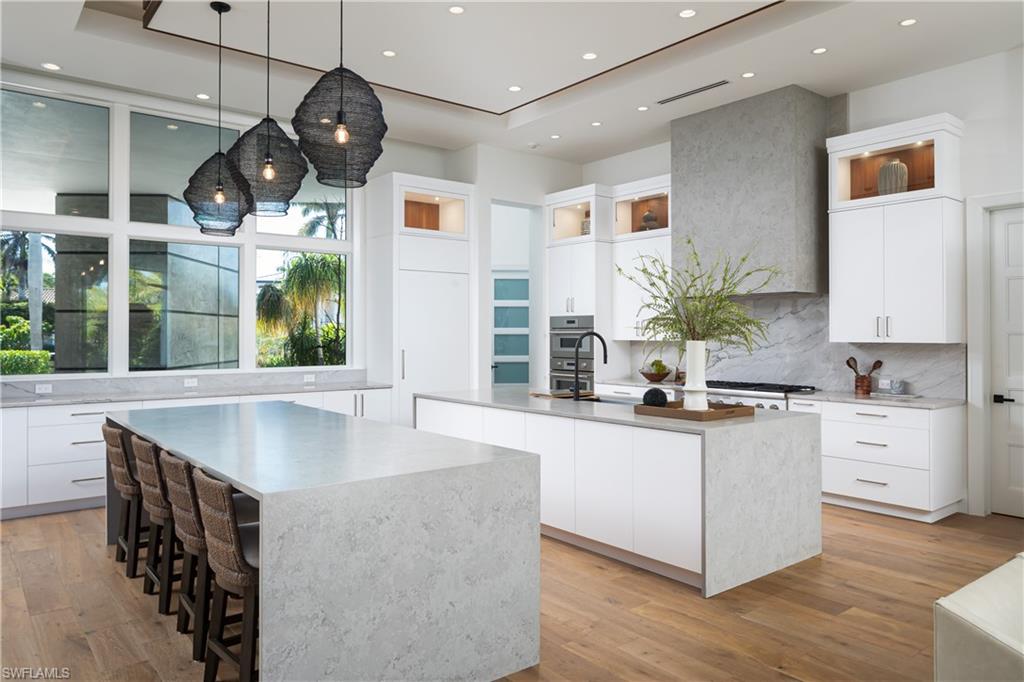 441 Mooring Line Drive Naples, FL 34102 - Photo 6 of 50 a kitchen with stainless steel appliances granite countertop a sink a stove and a wooden floors