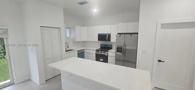 a kitchen with cabinets and stainless steel appliances