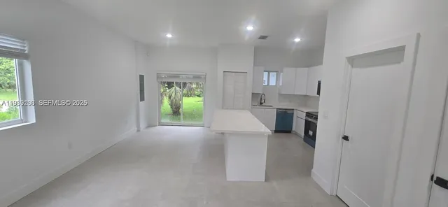 a open kitchen with white cabinets and stainless steel appliances