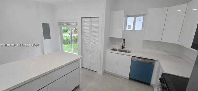 a room with a sink cabinets and a window