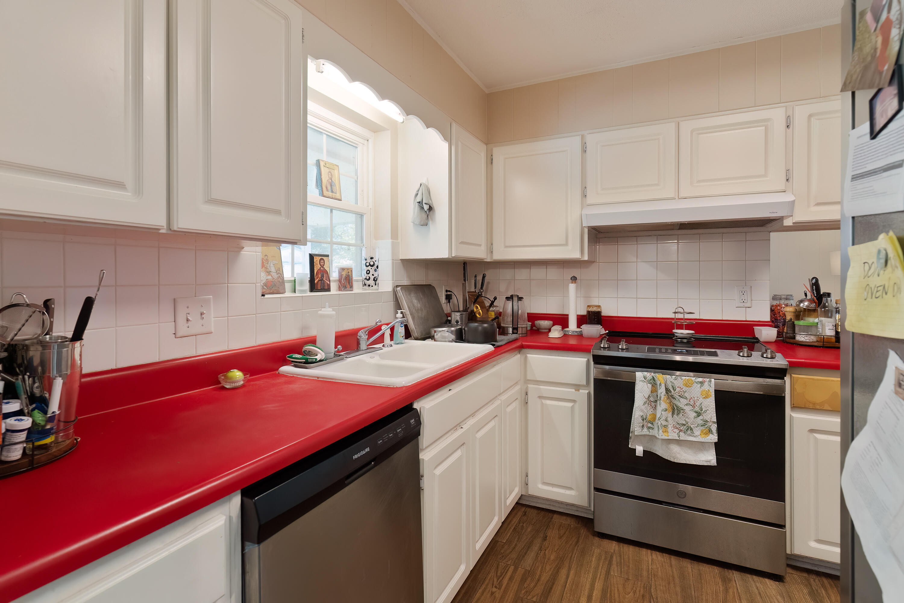 35 James Avenue Shalimar, FL 32579 - Photo 9 of 44 a kitchen with stainless steel appliances a sink dishwasher stove and white cabinets with wooden floor