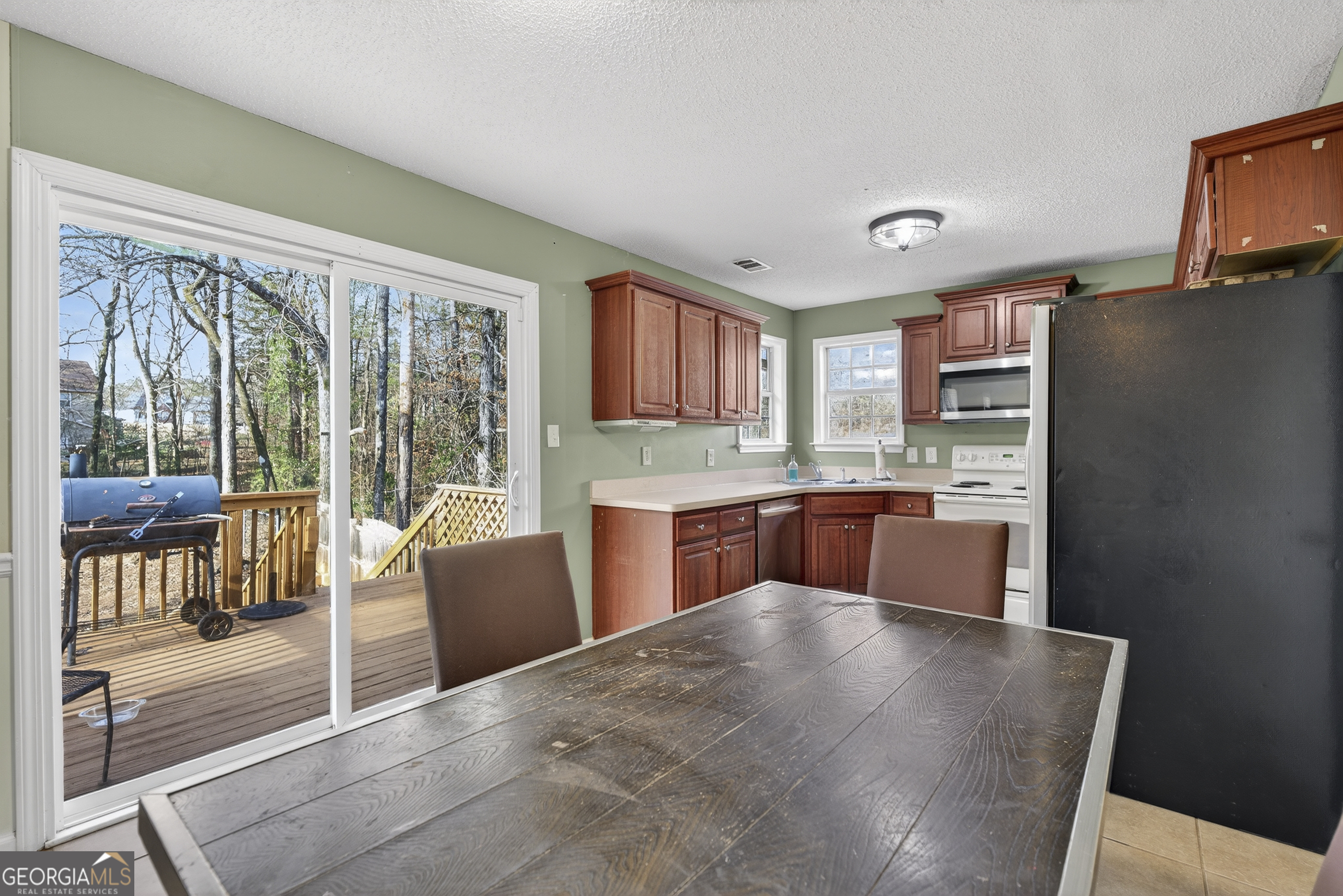 226 Amy Lane Gray, GA 31032 - Photo 15 of 46 a kitchen with stainless steel appliances kitchen island granite countertop a refrigerator a stove top oven and a view of living room