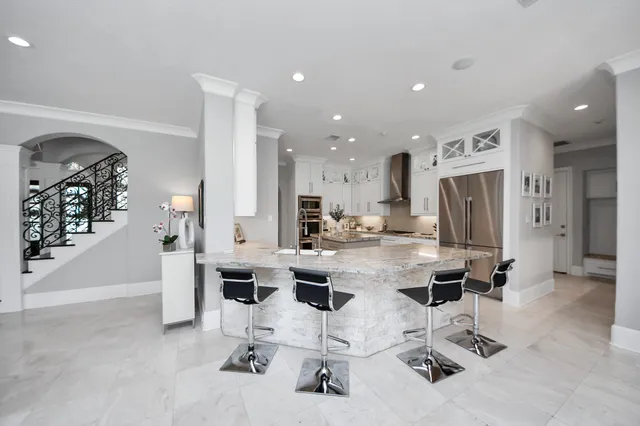 a kitchen with stainless steel appliances kitchen island granite countertop a refrigerator and cabinets