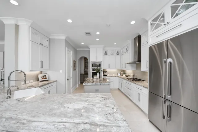 a kitchen with granite countertop a refrigerator and a sink