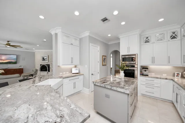 a kitchen with stainless steel appliances kitchen island granite countertop a refrigerator and a stove top oven