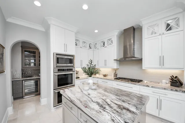 a kitchen with stainless steel appliances granite countertop a refrigerator a stove and a sink