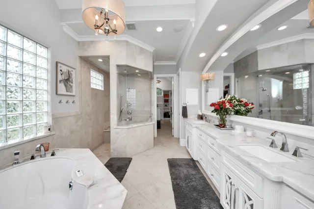a large spacious bathroom with a granite countertop sink a large mirror and shower