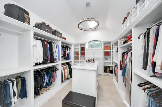 a view of walk in closet with clothes and shoes