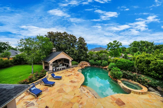 a view of backyard with swimming pool and seating space