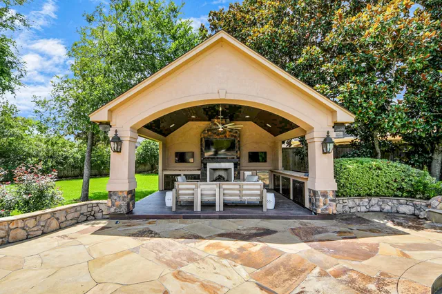 a outdoor living space with furniture a fireplace and a garden view