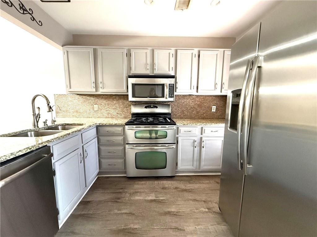 1555 Springleaf Court Southeast Smyrna, GA 30080 - Photo 3 of 19 a kitchen with granite countertop a refrigerator stove and microwave