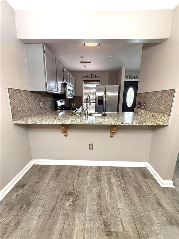 1555 Springleaf Court Southeast Smyrna, GA 30080 - Photo 5 of 19 a kitchen with stainless steel appliances granite countertop a sink a stove and a wooden floors