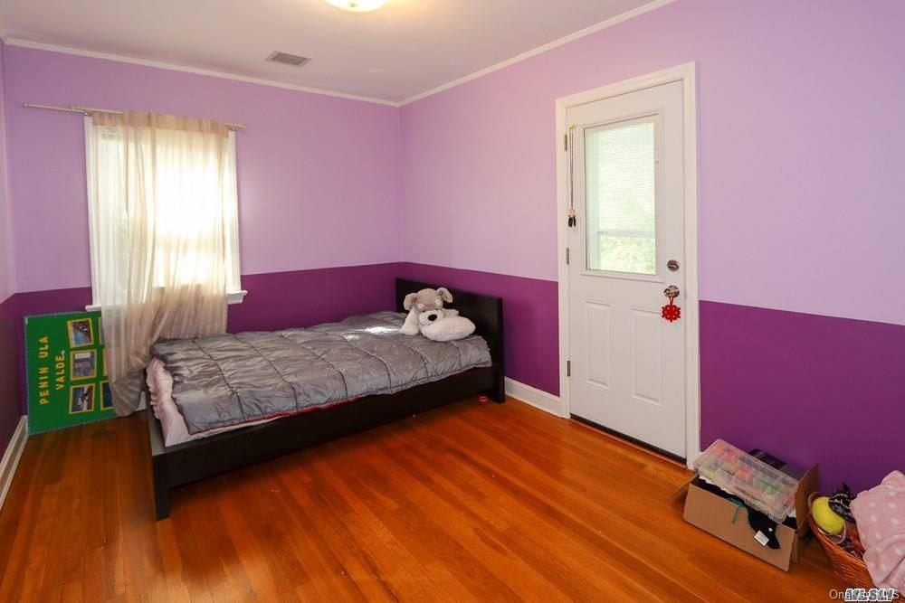 80-76 Springfield Boulevard Queens, NY 11427 - Photo 15 of 21 a bedroom with a bed and wooden floor