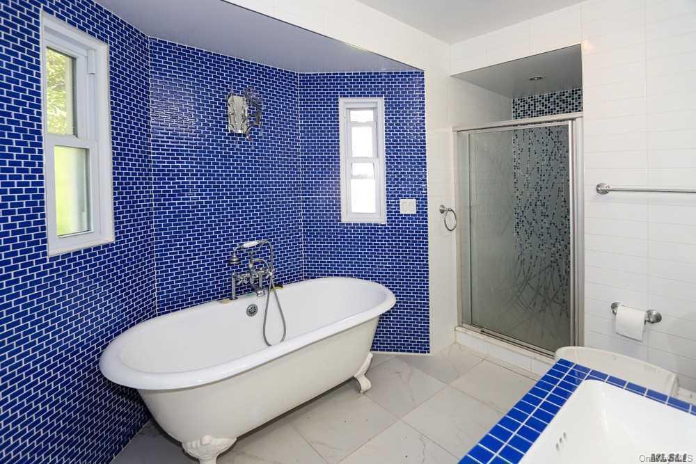 80-76 Springfield Boulevard Queens, NY 11427 - Photo 17 of 21 a bathroom with a bathtub and shower