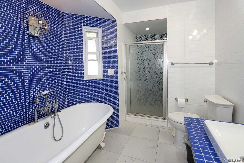 80-76 Springfield Boulevard Queens, NY 11427 - Photo 18 of 21 a bathroom with a granite countertop bathtub shower and toilet