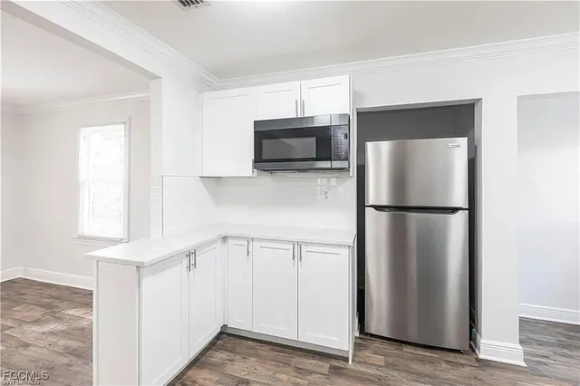 a kitchen with white cabinets and stainless steel appliances