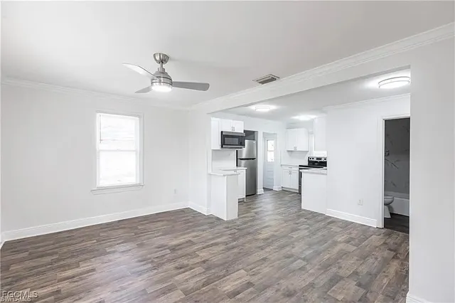 a view of a kitchen with wooden floor and a kitchen space