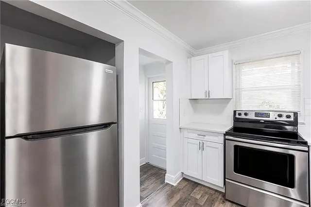 a kitchen with a refrigerator stove and white cabinets