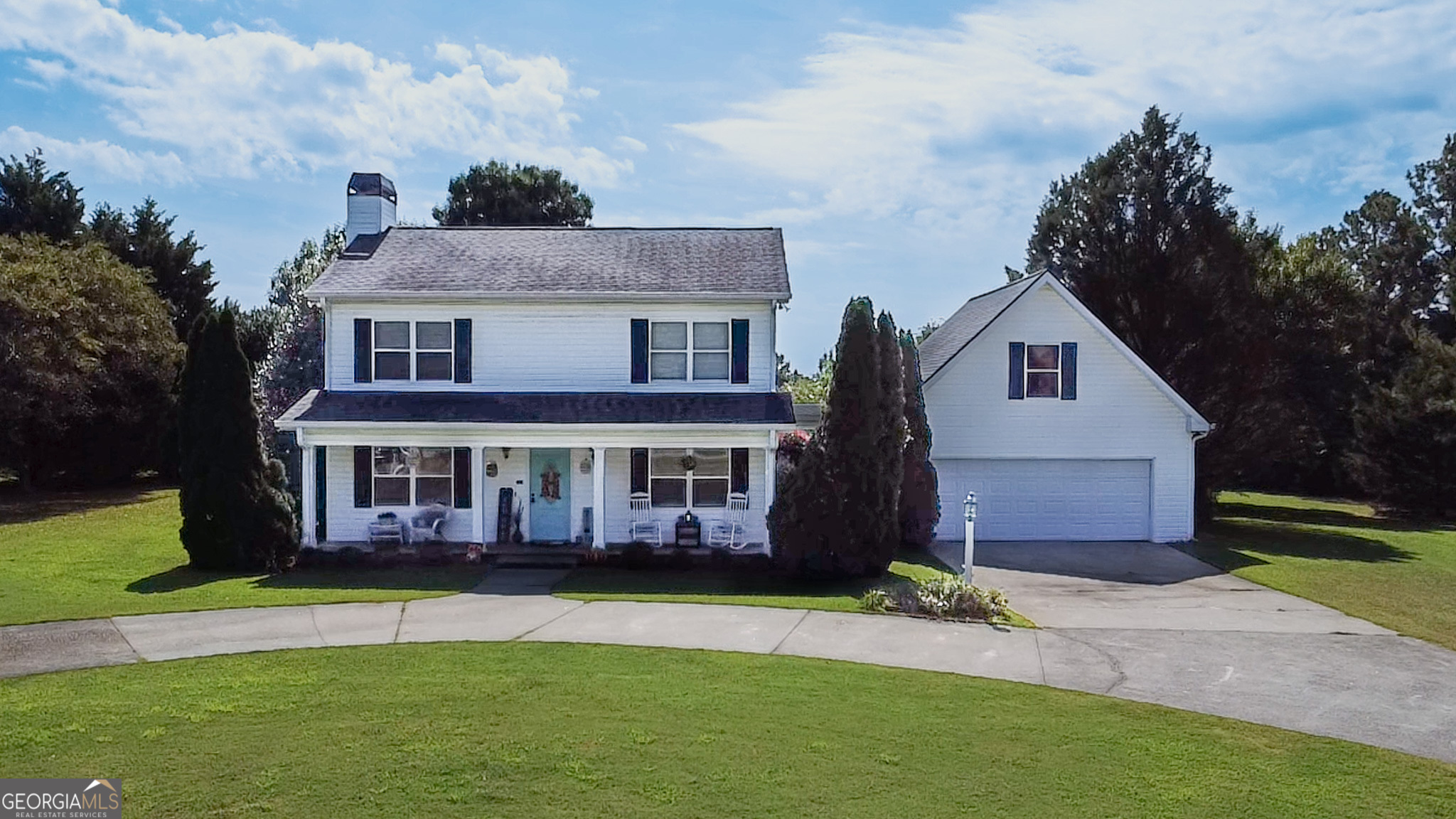 a front view of a house with a garden and yard