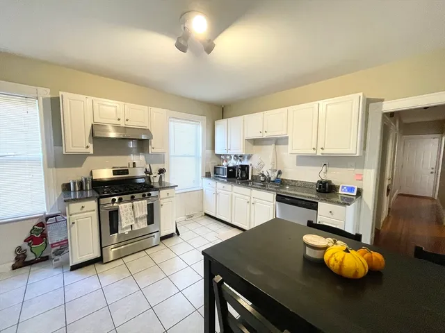 a kitchen with granite countertop a stove sink and cabinets