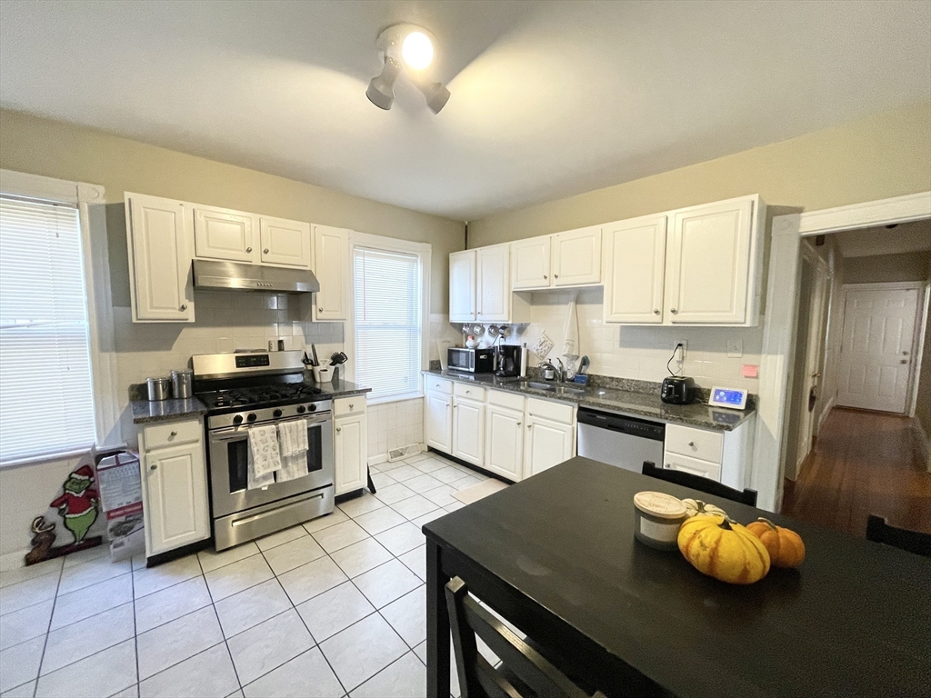 a kitchen with granite countertop a stove sink and cabinets