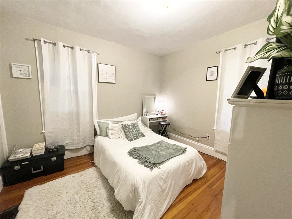 9 Taft Street, Unit 1 Boston, MA 02125 - Photo 11 of 15 a bedroom with a bed a couch and a window