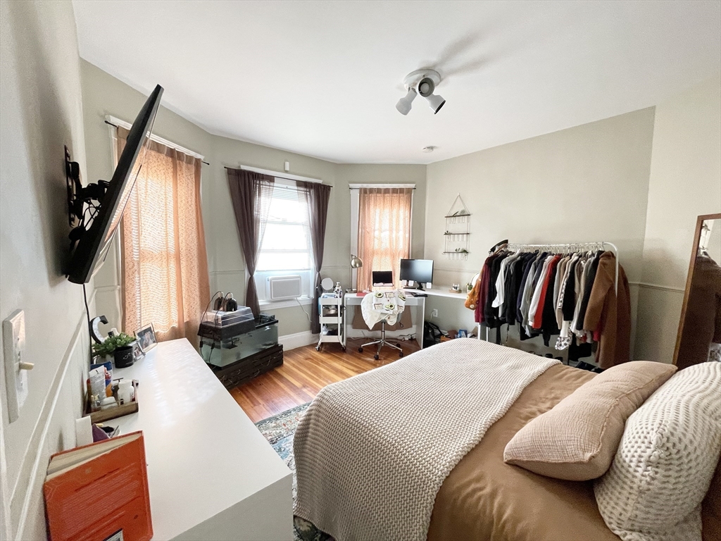 9 Taft Street, Unit 1 Boston, MA 02125 - Photo 5 of 15 a bedroom with a bed a flat screen tv and a large window