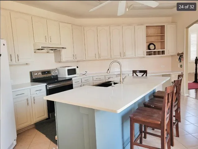 a kitchen with stainless steel appliances a table chairs and a refrigerator