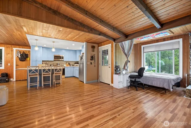 a living room filled with furniture and kitchen view