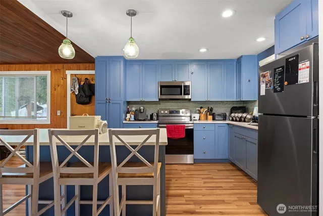 a kitchen with stainless steel appliances granite countertop a refrigerator a stove top oven a sink dishwasher and wooden cabinets