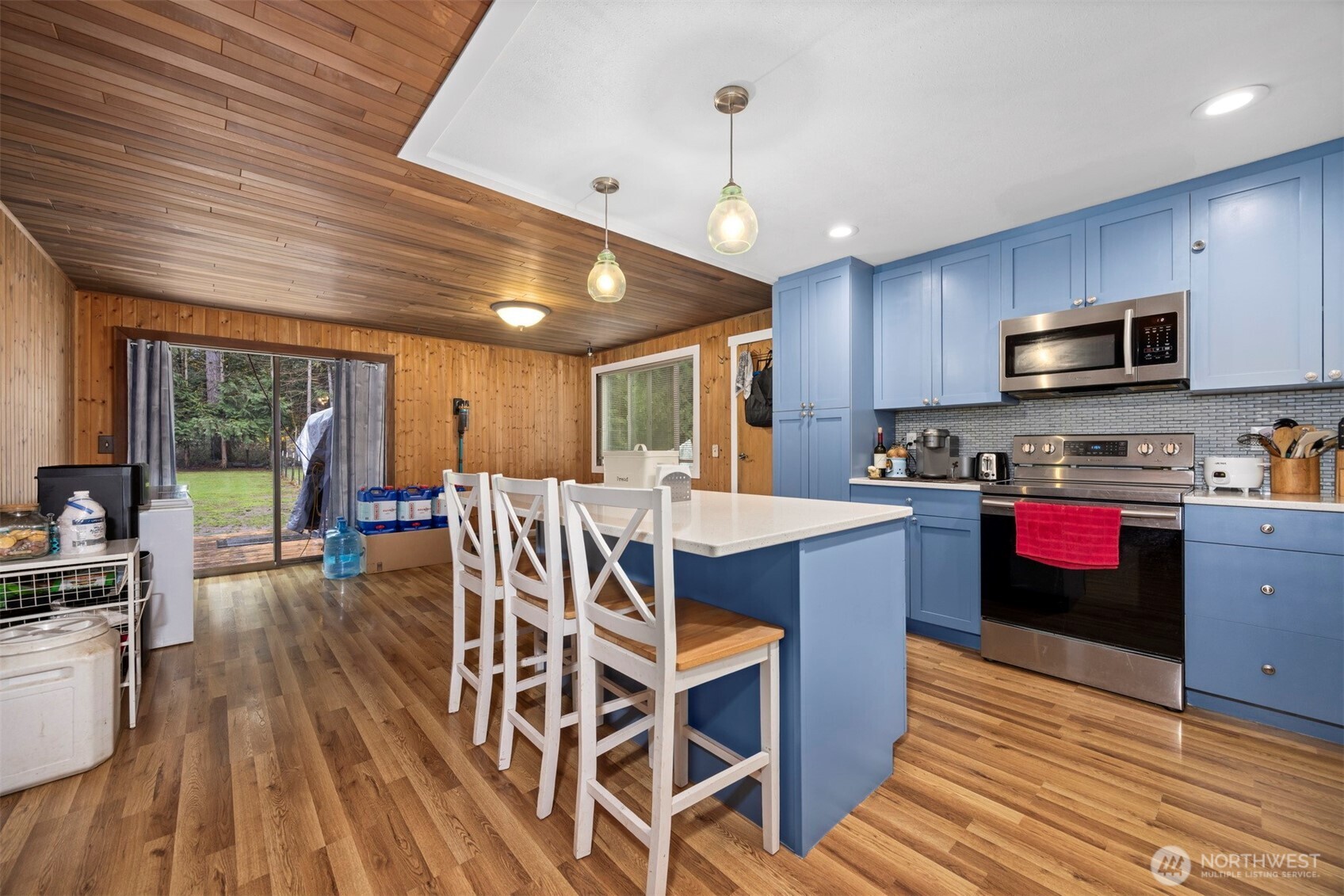 3630 Sorenson Road Everson, WA 98247 - Photo 5 of 39 a kitchen with stainless steel appliances kitchen island granite countertop a stove a refrigerator a sink a dining table and chairs with wooden floor