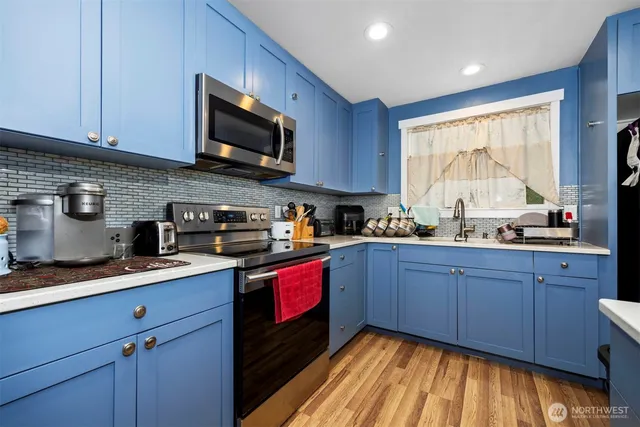 a kitchen with stainless steel appliances granite countertop wooden cabinets a stove a sink and a window