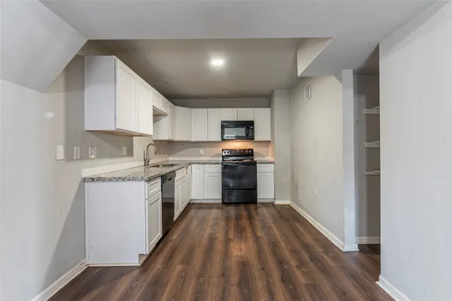 a kitchen with granite countertop a stove top oven and sink