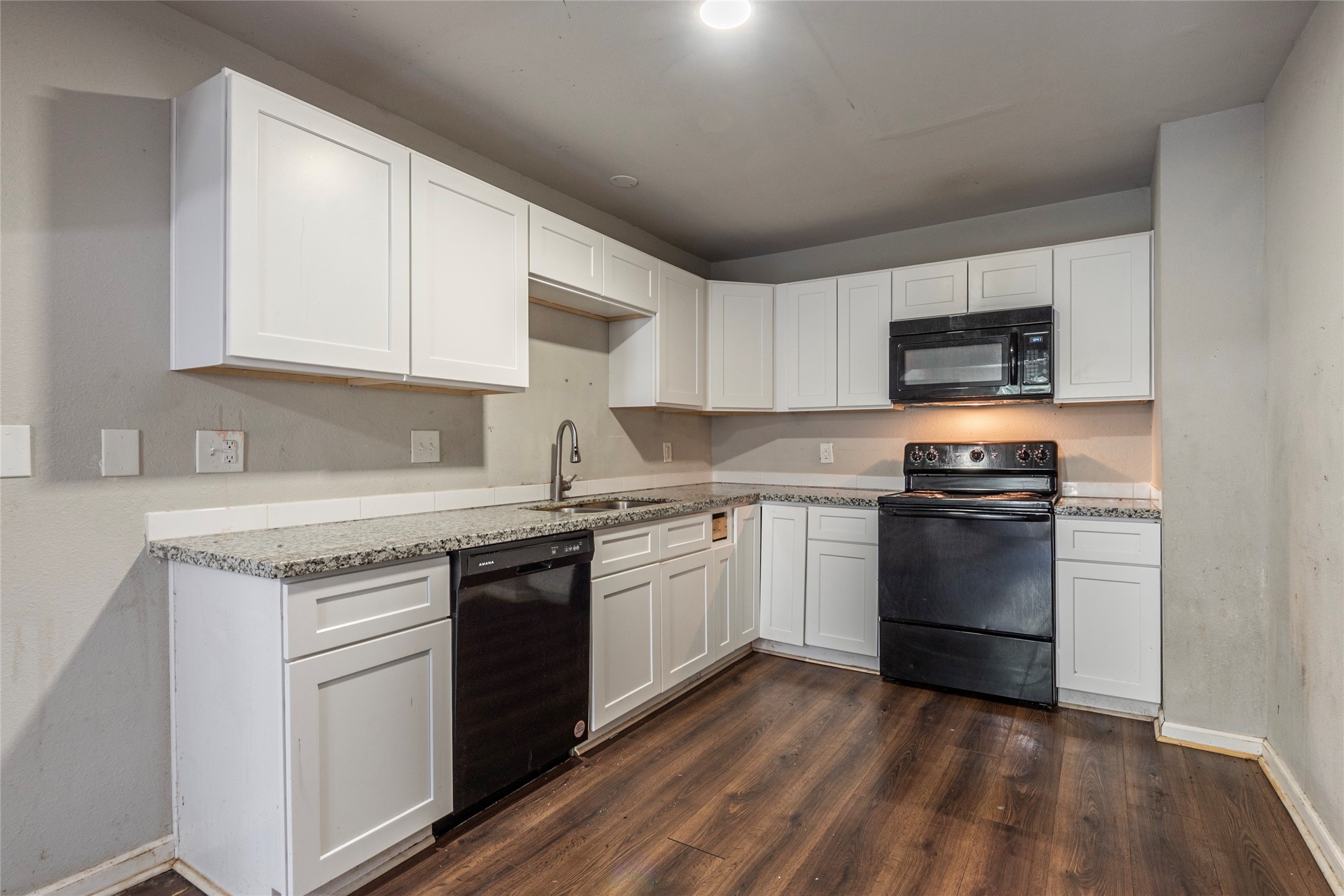 2801 Virginia Street, Unit B Baytown, TX 77520 - Photo 7 of 20 a kitchen with granite countertop a stove top oven and sink