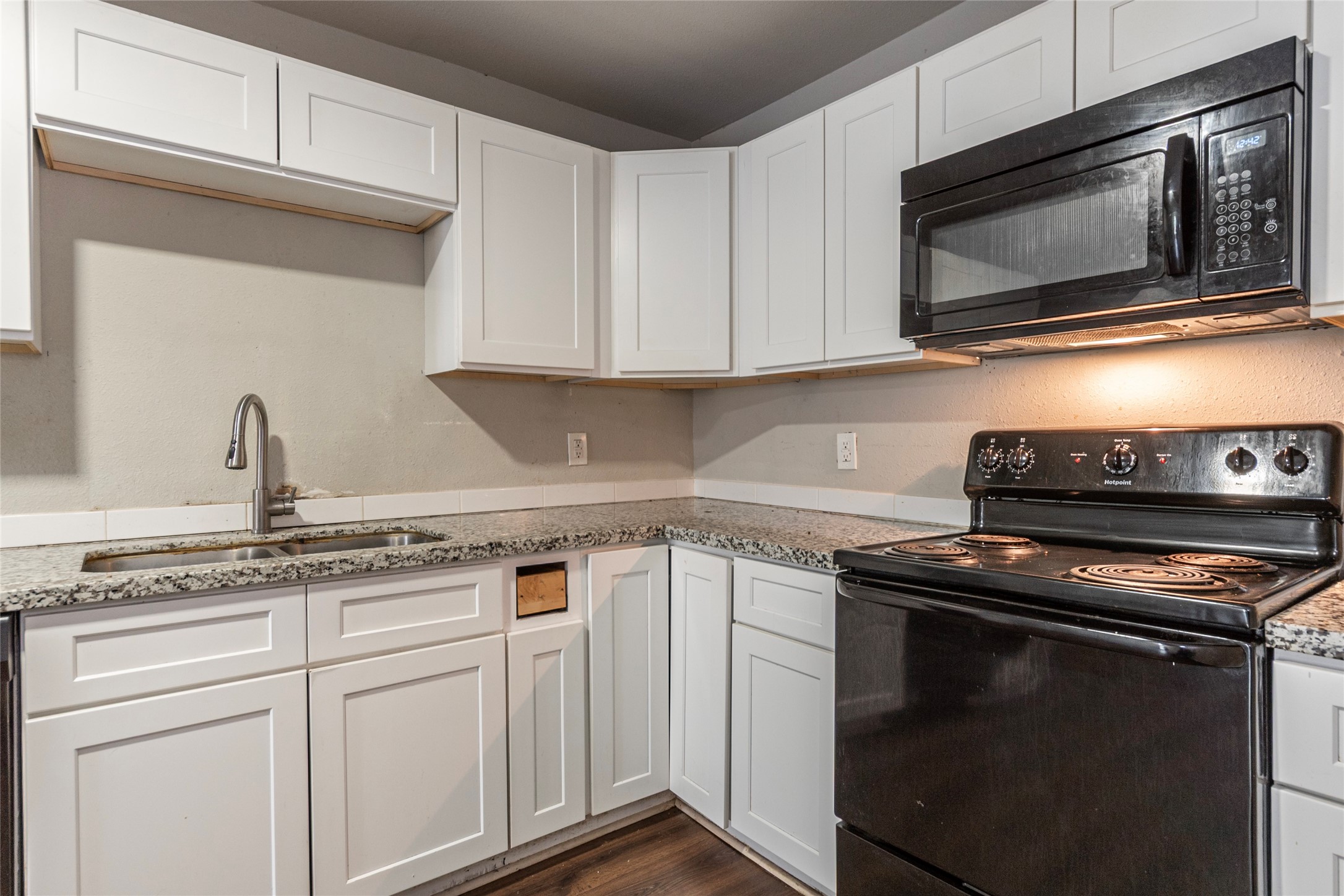 2801 Virginia Street, Unit B Baytown, TX 77520 - Photo 9 of 20 a kitchen with stainless steel appliances granite countertop white cabinets and a stove top oven