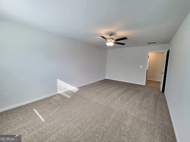 an empty room with a ceiling fan and a window