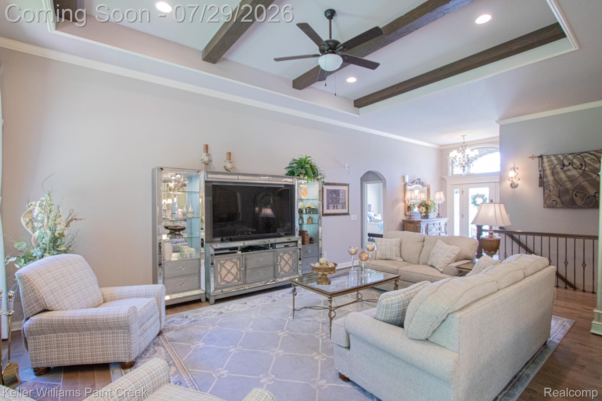 49118 Ridgeview Drive Macomb, MI 48044 - Photo 8 of 57 Spacious living area featuring a tray ceiling with exposed wood beams, recessed lighting, and a ceiling fan