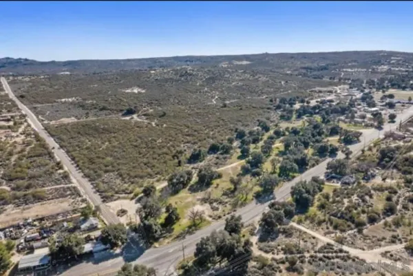 an aerial view of house with yard and mountain view in back