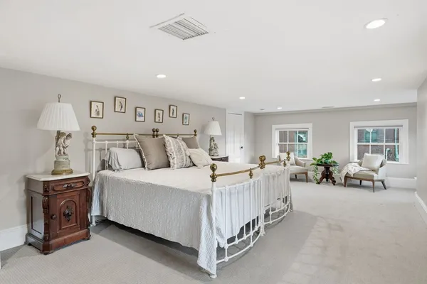 a bathroom with a granite countertop toilet a sink a mirror a window and a shower