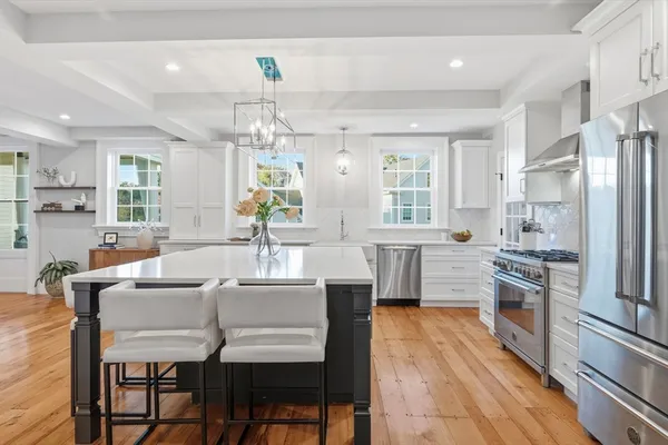 a kitchen with granite countertop a sink appliances cabinets and wooden floor
