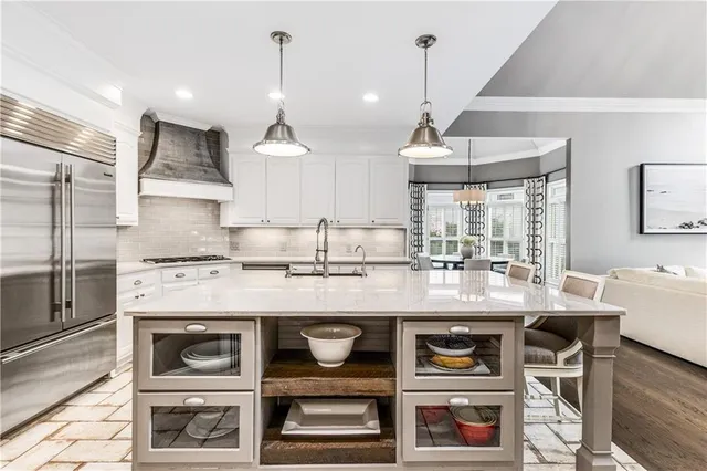 a kitchen with stainless steel appliances granite countertop a refrigerator and a sink