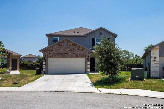 a front view of a house with a yard and potted plants