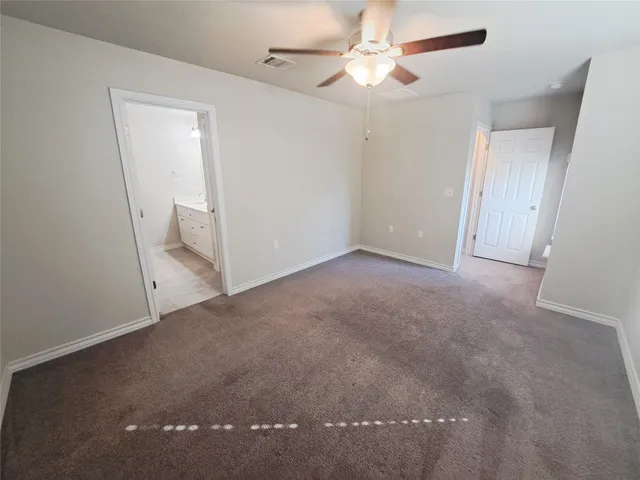 an empty room with a ceiling fan and a window