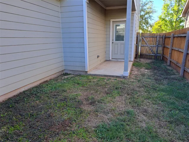 a view of backyard and wooden fence